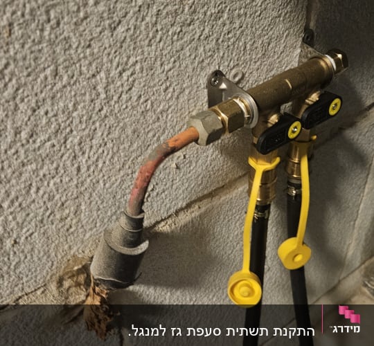 צינור גז עם ברזים צהובים על קיר בטון